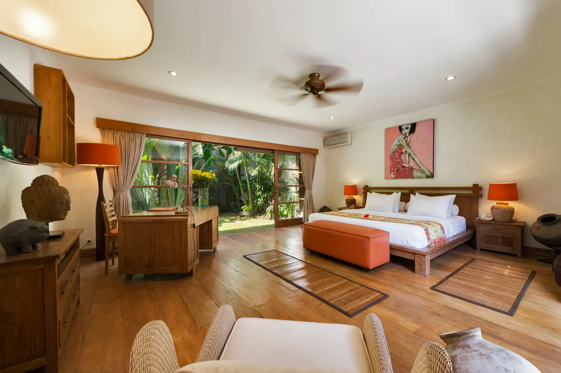 Chambre ouverte sur le jardin : lit en teck, fauteuils en rotin