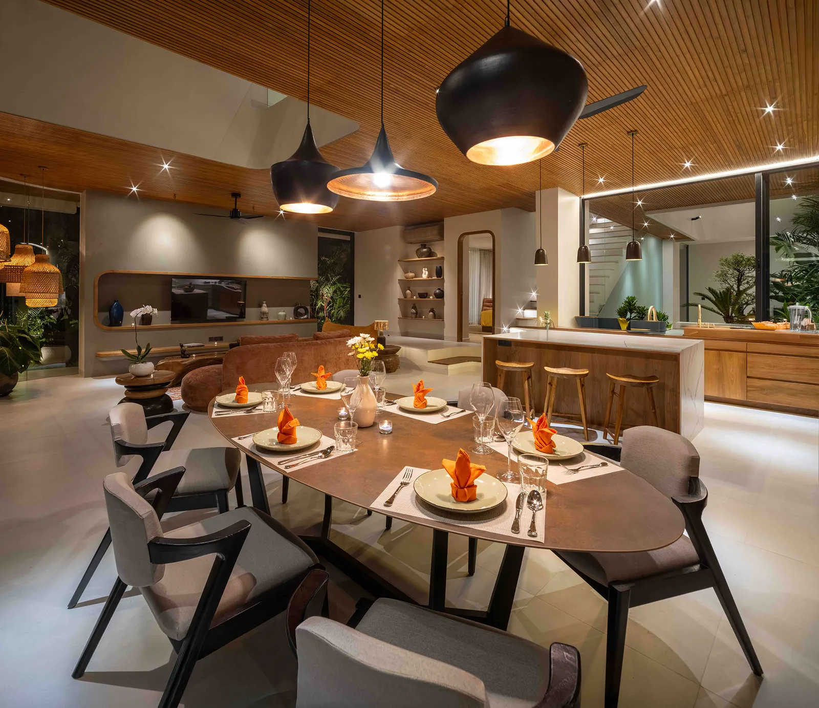 Table de repas ovale en bois massif et ses fauteuils, dressée pour huit
