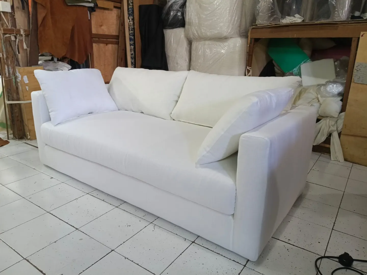 Canapé trois places tapissé en tissu blanc