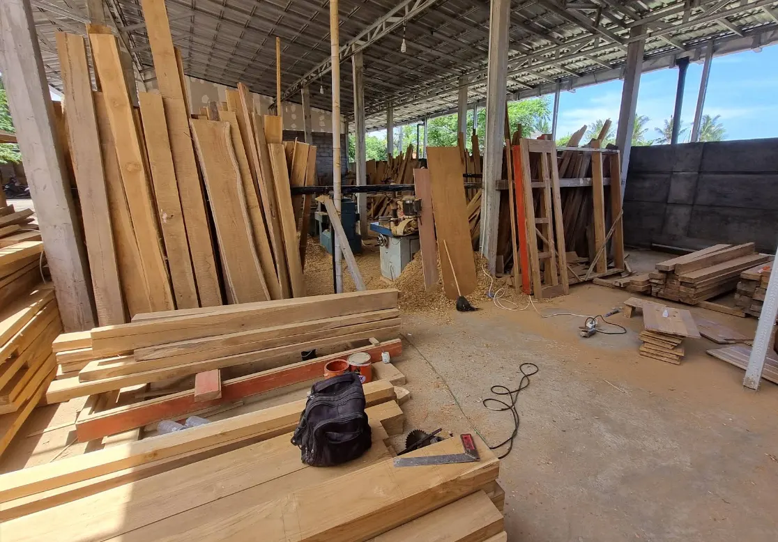 Stock de planches de teck sous hangar, séchage avant débit