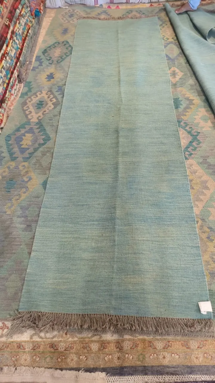 Tapis uni bleu-vert à franges nouées