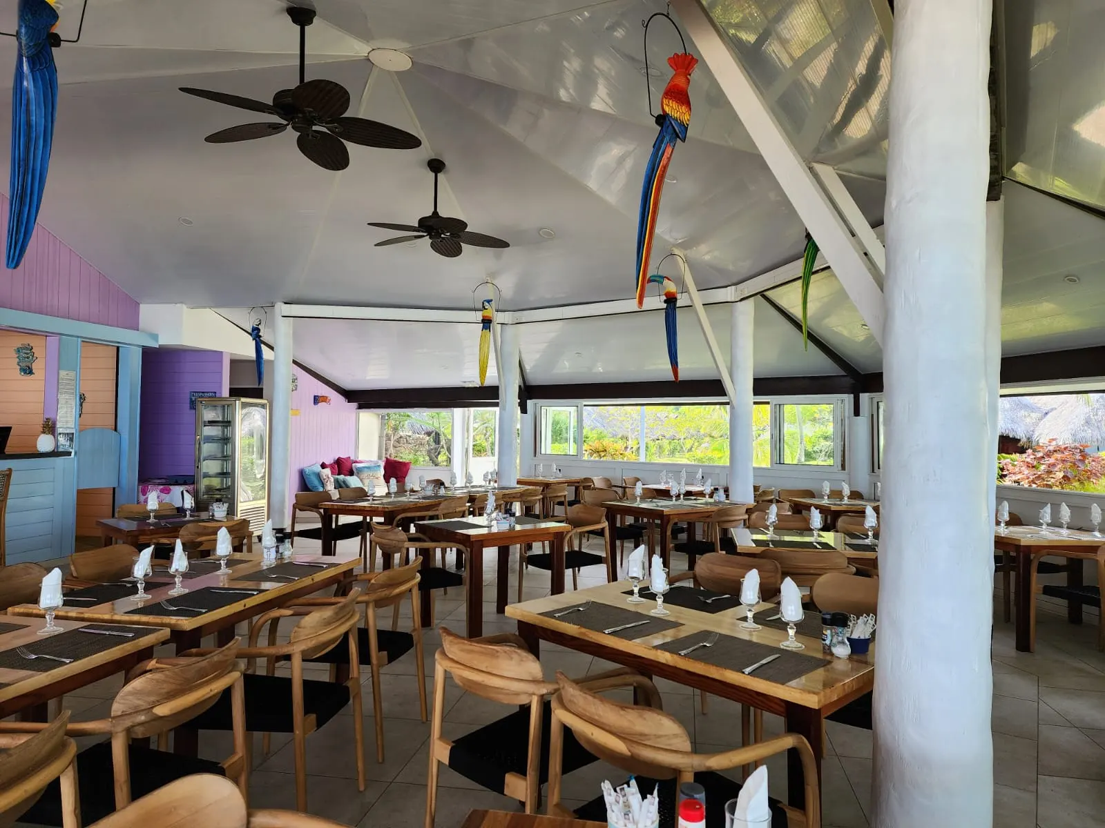 La salle complète — une douzaine de tables et leurs assises livrées